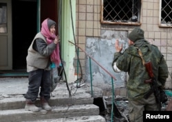 Ресей басқыншылығынан қирап-бүлінген Мариуполь қаласында жергілікті тұрғын ресейлік әскеримен сөйлесіп тұр. Украина, 31 наурыз 2022 жыл.