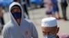 Kazakhstan - Local residents wearing protective masks walk through a checkpoint, set up to lock down the city to prevent the spread of the coronavirus disease (COVID-19), on the outskirts of Almaty, Kazakhstan May 11, 2020. REUTERS/Pavel Mikheyev