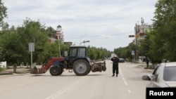 Қарулы шабуылға күдіктілерге қарсы арнайы операция жүріп жатқан көшеге ешкімді өткізбей тұрған полиция қызметкері. Ақтөбе, 10 маусым 2016 жыл.